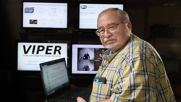 Headshot of Edward Delp sitting in front of a laptop and four screens showing manipulated imagery