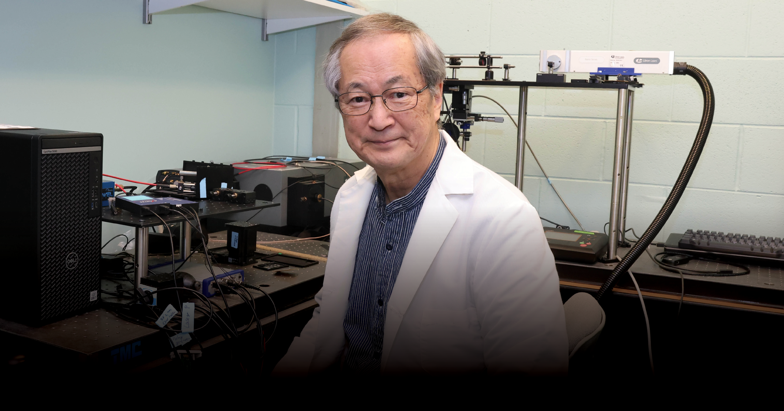 Masanobu Yamamoto, wearing a white lab coats, sits in a lab.