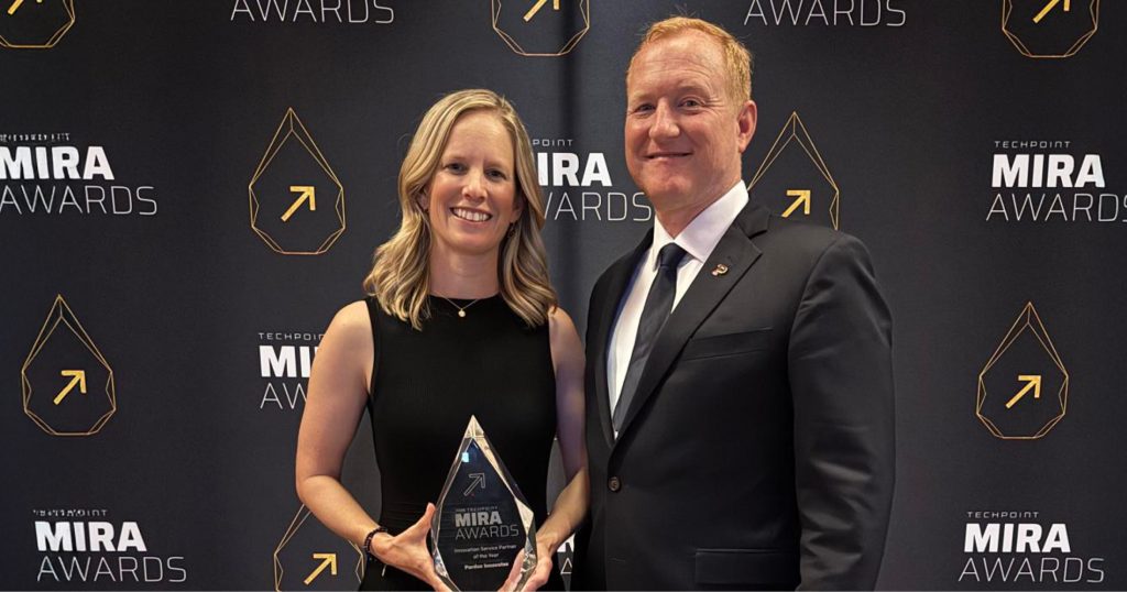 Brooke Beier and Chad Pittman poses in front of a Mira Awards step and repeat.