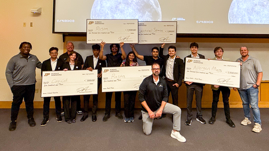 Moonshot Pitch Challenge winners holding big checks.