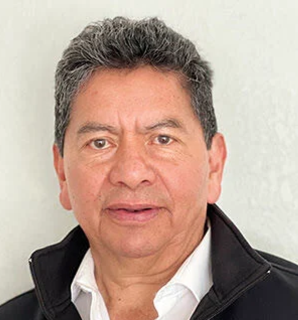 Portrait of a middle-aged man with salt-and-pepper hair wearing a white shirt and black jacket, facing the camera.